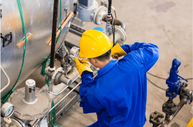 Worker checking machinery in factory