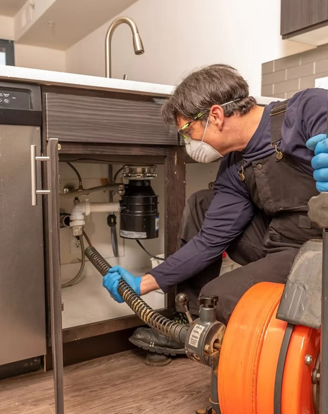 Plumber fixing kitchen sink pipe