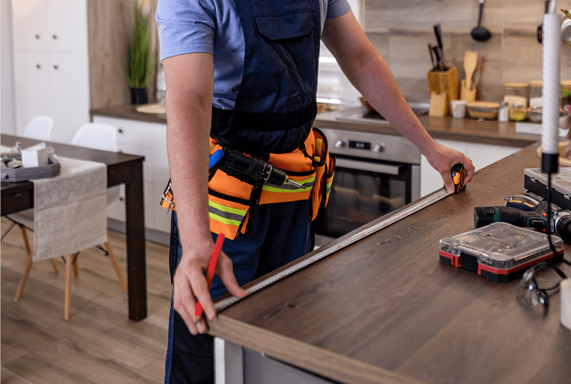 Person in overalls adjusting kitchen counter