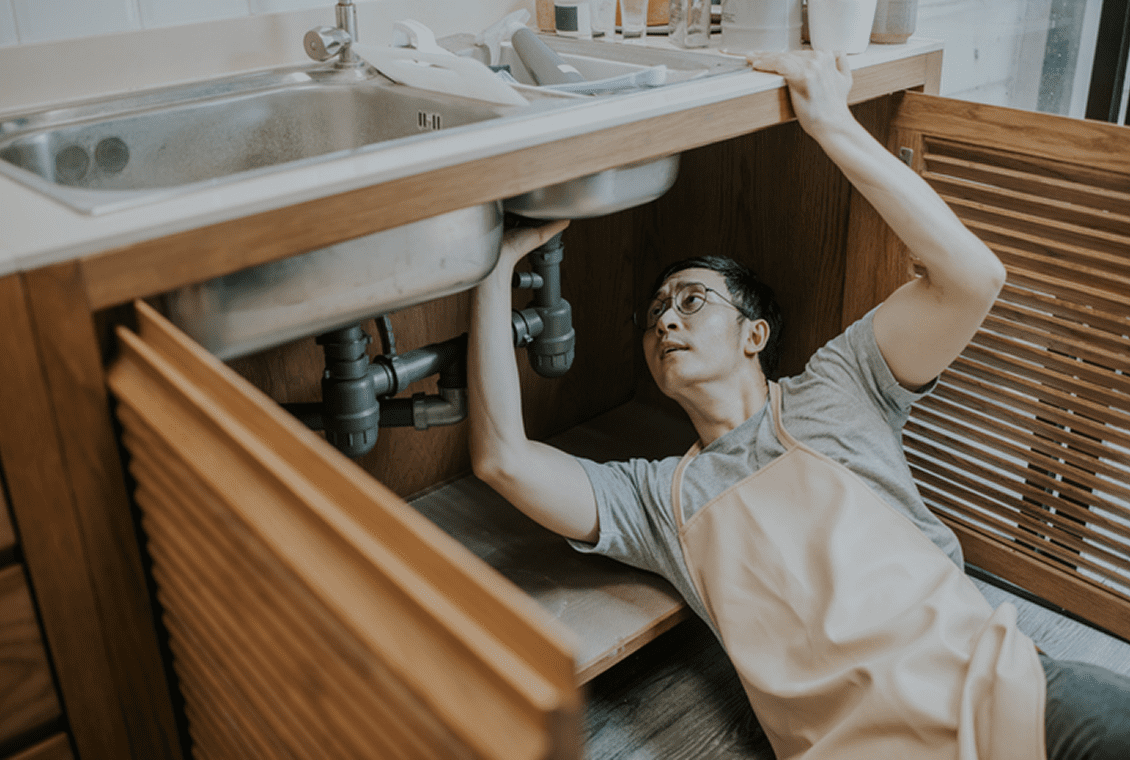 Person working under kitchen sink