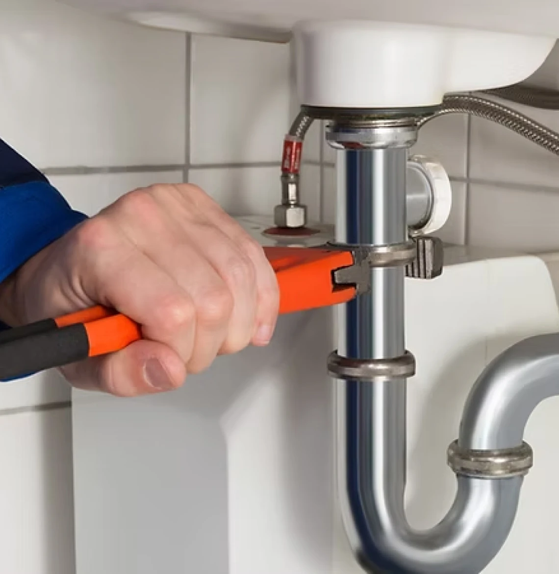 Hand using wrench on sink pipe