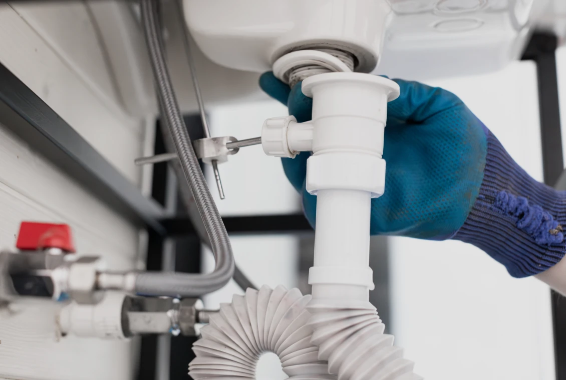 Gloved hand fixing plumbing connection